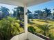 Balcony view showcasing the lush landscaping, manicured lawn, mature palm trees, and serene community setting at 3100 Hartford N St # 221, St Petersburg, FL 33713