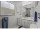 Clean, well-lit bathroom with white cabinetry, marble countertop, and a large, framed mirror at 3457 Cyclone Dr, Weeki Wachee, FL 34607