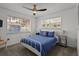 Bright bedroom with a white frame bed, ceiling fan, and two large windows with natural light at 3457 Cyclone Dr, Weeki Wachee, FL 34607