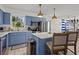 Charming blue and white kitchen with stainless steel appliances, island, and eat-in bar at 3457 Cyclone Dr, Weeki Wachee, FL 34607