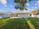 Lush backyard view showcasing the home's rear exterior and a screened-in patio at 3646 Springfield Dr, Holiday, FL 34691