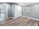 Bright bedroom featuring wood-look floors, a double closet, a large window, and light gray walls at 3755 10Th S Ave, St Petersburg, FL 33711