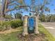 A welcoming Shore Acres community sign, nestled amidst lush greenery and vibrant flowers under a blue sky at 3801 Alabama Ne Ave, St Petersburg, FL 33703