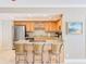 Kitchen featuring bar seating, wooden cabinets, and modern appliances at 3820 Gulf Blvd # 802, St Pete Beach, FL 33706