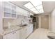 Kitchen with white cabinets, stainless steel appliances, and tile flooring at 3820 Gulf Blvd # 802, St Pete Beach, FL 33706