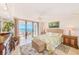 Inviting bedroom featuring a tropical-themed bedspread, balcony access, and stylish furnishings at 3820 Gulf Blvd # 802, St Pete Beach, FL 33706