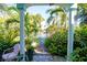 Inviting walkway through lush tropical plants, leading to a charming home with a white picket fence at 4038 2Nd N Ave, St Petersburg, FL 33713