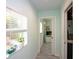 Bright hallway with tiled floors, a window with a plant, and a view into another room at 4038 2Nd N Ave, St Petersburg, FL 33713