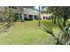 Expansive grassy backyard area with mature trees and multi-story buildings at 4133 Bismarck Palm Dr, Tampa, FL 33610