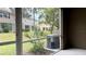 View from screened patio of backyard with grass and buildings in the distance at 4133 Bismarck Palm Dr, Tampa, FL 33610