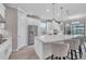 Modern kitchen featuring white cabinetry, stainless steel appliances, large island with seating, and stylish pendant lights at 4314 Graticola Rd, Wesley Chapel, FL 33543