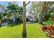 Lovely backyard showcasing a mix of green lawn, mature trees, and well-kept landscaping at 4915 Churchill Pl, Land O Lakes, FL 34639