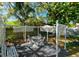 Charming backyard featuring a shaded patio with outdoor furniture and mature trees at 4915 Churchill Pl, Land O Lakes, FL 34639