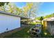 Well-maintained backyard featuring a screen porch, gardening beds, and lush green lawn at 4915 Churchill Pl, Land O Lakes, FL 34639