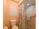 Tiled bathroom featuring a toilet, shower and a stylish shower curtain at 4915 Churchill Pl, Land O Lakes, FL 34639