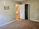 A carpeted bedroom with an open closet and a view through a doorway to another room at 4915 Churchill Pl, Land O Lakes, FL 34639