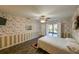 Comfortable bedroom featuring floral wallpaper, wood floors, and access to an outdoor patio at 4915 Churchill Pl, Land O Lakes, FL 34639