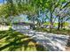 Wide view of a single-story home with a spacious driveway and a well-maintained front lawn, shaded by mature trees at 4915 Churchill Pl, Land O Lakes, FL 34639
