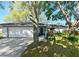 Charming single-story home featuring an attached two-car garage and beautifully landscaped front yard with mature trees at 4915 Churchill Pl, Land O Lakes, FL 34639