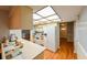 Eat-in kitchen features wood-look flooring, white appliances, and a unique skylight at 4915 Churchill Pl, Land O Lakes, FL 34639