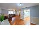 Bright living room with wood floors, neutral walls, and a ceiling fan, seamlessly flowing into the kitchen area at 4915 Churchill Pl, Land O Lakes, FL 34639