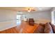 Spacious living room featuring hardwood floors, neutral tones, a ceiling fan, and a sliding door to the backyard at 4915 Churchill Pl, Land O Lakes, FL 34639