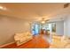 Open concept living room with wood-look flooring, access to kitchen, and access to the screened lanai at 4915 Churchill Pl, Land O Lakes, FL 34639