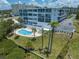 Aerial view of complex with a pool and surrounding trees, showing community features and well manicured lawns at 50 Harbor View Ln # 21, Belleair Bluffs, FL 33770