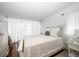 Bright and airy bedroom with soft, all-white decor, complemented by wood floors and natural light at 50 Harbor View Ln # 21, Belleair Bluffs, FL 33770