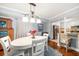 Bright dining area adjacent to a modern kitchen with hardwood floors and stylish lighting at 50 Harbor View Ln # 21, Belleair Bluffs, FL 33770