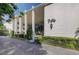 White condominium building with well manicured landscaping, tall pillars and elegant exterior lighting at 50 Harbor View Ln # 21, Belleair Bluffs, FL 33770