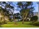 Well-manicured front lawn with mature trees, offering a serene and picturesque setting at 50 Harbor View Ln # 21, Belleair Bluffs, FL 33770