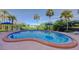 Inviting pool with clear blue water, surrounded by palm trees and lush landscaping, perfect for relaxation and enjoyment at 50 Harbor View Ln # 21, Belleair Bluffs, FL 33770
