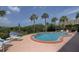 Inviting outdoor pool surrounded by lush greenery and palm trees, perfect for relaxation at 50 Harbor View Ln # 21, Belleair Bluffs, FL 33770