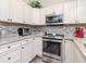 Bright kitchen features white cabinets, stainless steel appliances, mosaic backsplash, and granite countertops at 5100 Burchette Rd # 500, Tampa, FL 33647
