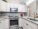 Bright kitchen features white cabinets, stainless steel appliances, mosaic backsplash, and granite countertops at 5100 Burchette Rd # 500, Tampa, FL 33647