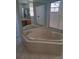 Elegant bathroom featuring a corner tub, tile surround, and natural light from nearby window at 5261 Camberlea Ave, Zephyrhills, FL 33541
