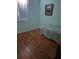 Cozy bedroom featuring sleek wood floors and a bright window at 5261 Camberlea Ave, Zephyrhills, FL 33541
