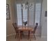 Bright breakfast nook featuring a wood table set, chandelier lighting, and shuttered windows at 5261 Camberlea Ave, Zephyrhills, FL 33541
