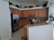 Spacious kitchen featuring stainless steel appliances, a large island, and wood cabinets at 5261 Camberlea Ave, Zephyrhills, FL 33541