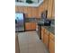 Well-equipped kitchen featuring stainless steel appliances, wood cabinets, and granite countertops at 5261 Camberlea Ave, Zephyrhills, FL 33541