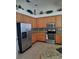 Well-lit kitchen featuring oak cabinets, granite countertops, stainless steel appliances, and stylish backsplash at 5261 Camberlea Ave, Zephyrhills, FL 33541