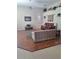 Spacious living room with vaulted ceiling, wood floors, a decorative tapestry, and plantation shutters at 5261 Camberlea Ave, Zephyrhills, FL 33541