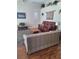 Comfortable living room with vaulted ceiling, wood floors, a decorative tapestry, and plantation shutters at 5261 Camberlea Ave, Zephyrhills, FL 33541