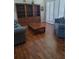 Cozy living room with wood floors, a large built-in bookcase, and natural light from the shutters at 5261 Camberlea Ave, Zephyrhills, FL 33541