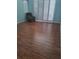 Bright, spacious living room with wood floors, shuttered windows, and a comfortable green recliner at 5261 Camberlea Ave, Zephyrhills, FL 33541