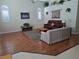 Bright living room boasts wood laminate flooring and high ceilings with decorative accents and neutral walls at 5261 Camberlea Ave, Zephyrhills, FL 33541