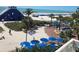 Expansive beachfront area with recreational amenities, palm trees, and a lively crowd enjoying the sunny weather at 5500 Gulf Blvd # 4226, St Pete Beach, FL 33706