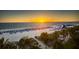 Aerial beach view at sunset with chairs, umbrellas, and an inflatable slide at 5500 Gulf Blvd # 4226, St Pete Beach, FL 33706