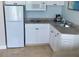 Efficient kitchen with white cabinets, modern appliances, granite counters, and tile floors for simple meal preparation at 5500 Gulf Blvd # 4226, St Pete Beach, FL 33706